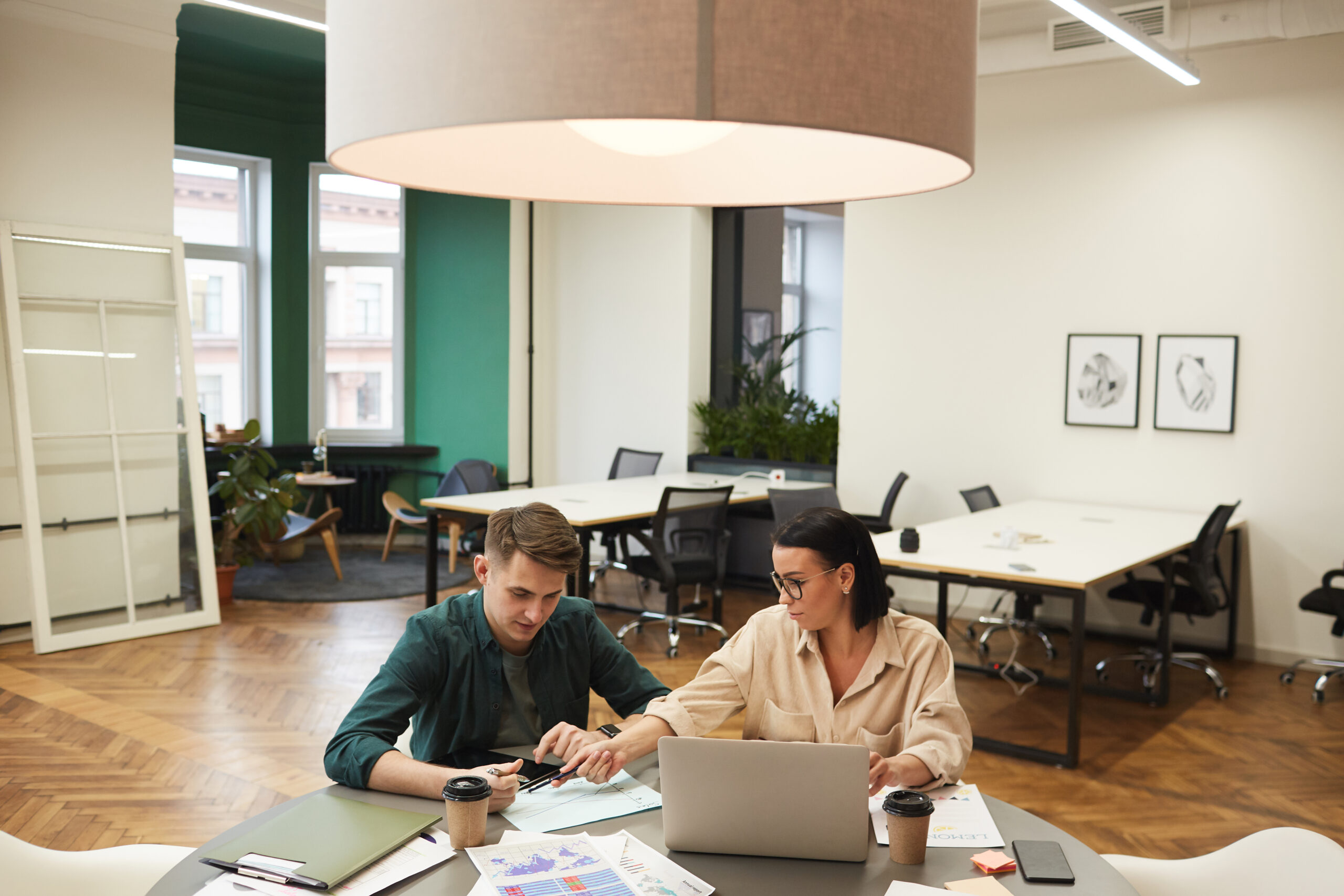 Two individuals collaborating on a laptop in a office | Jacko Law Group, PC