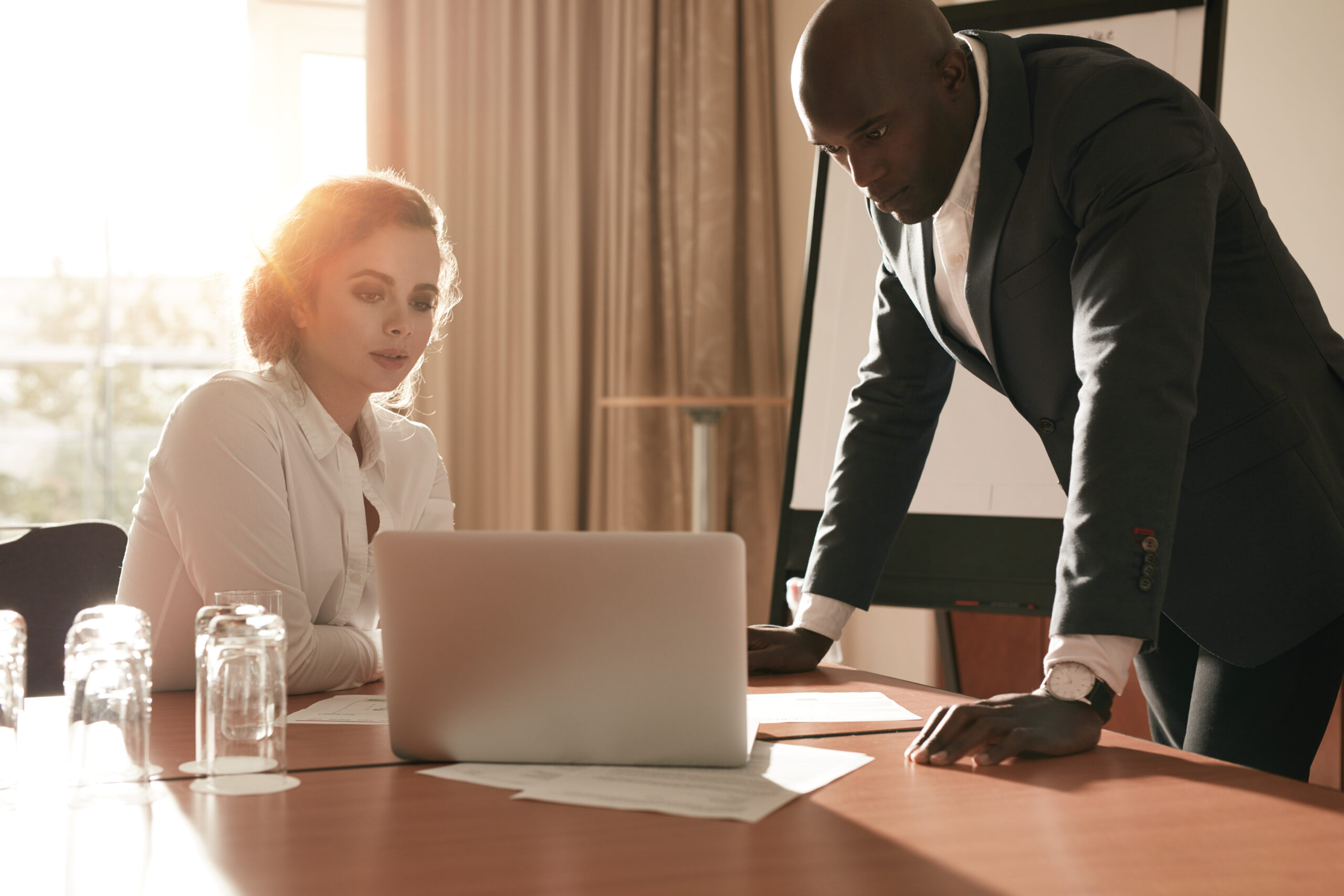 A man in a suit leans over a table with a laptop | Jacko Law Group, PC