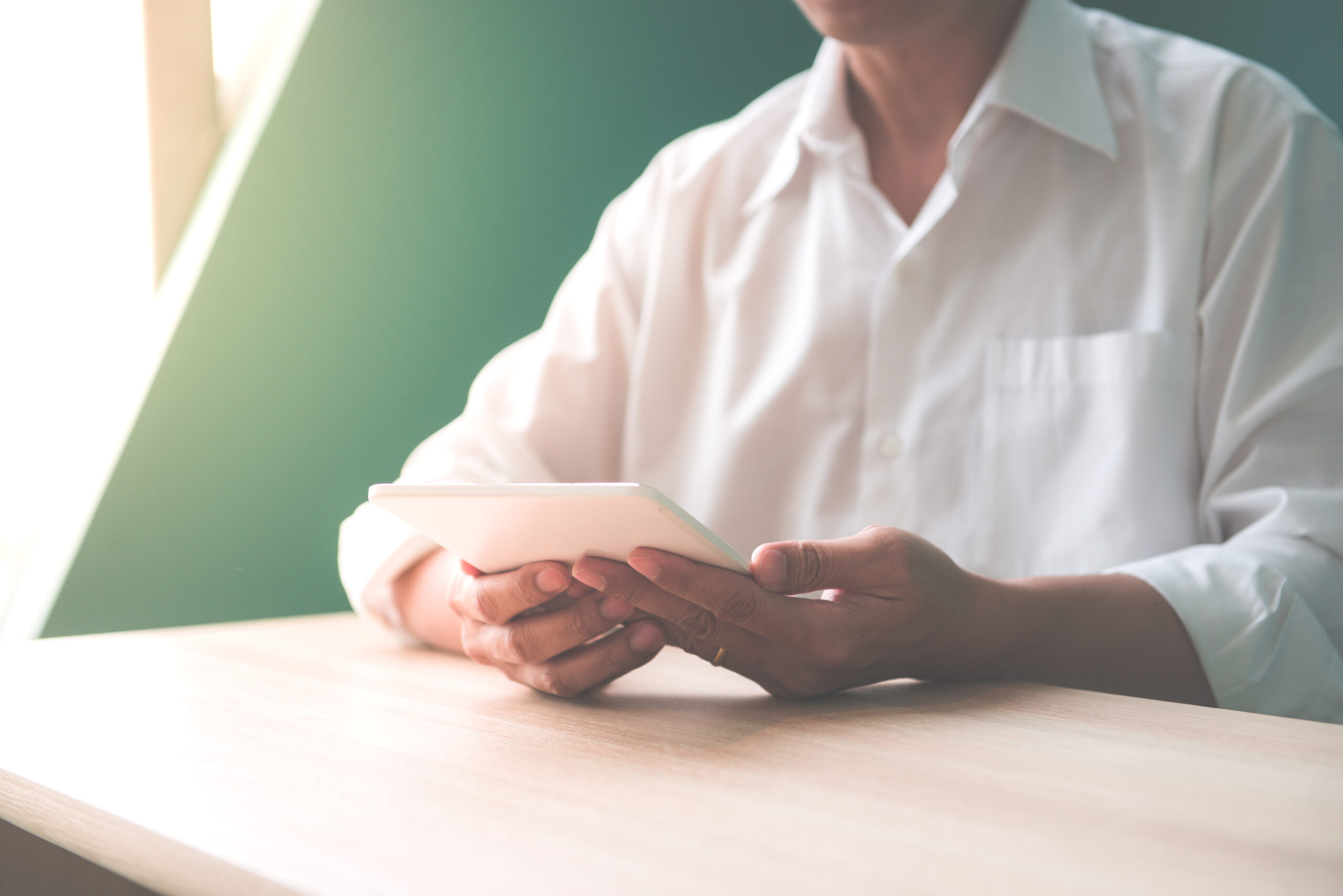 A person in a white shirt holds a tablet in their hands | Jacko Law Group, PC