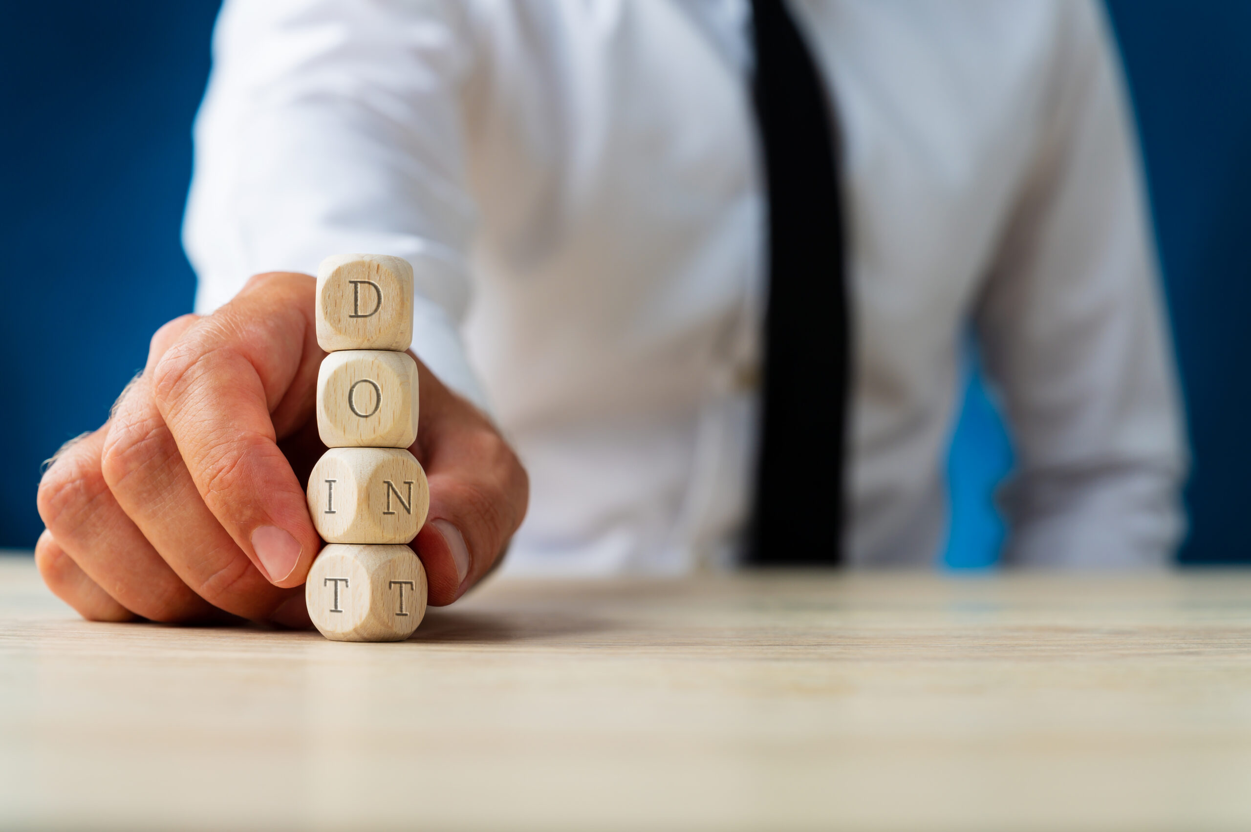 A person in a shirt and tie holds wooden blocks | Jacko Law Group, PC