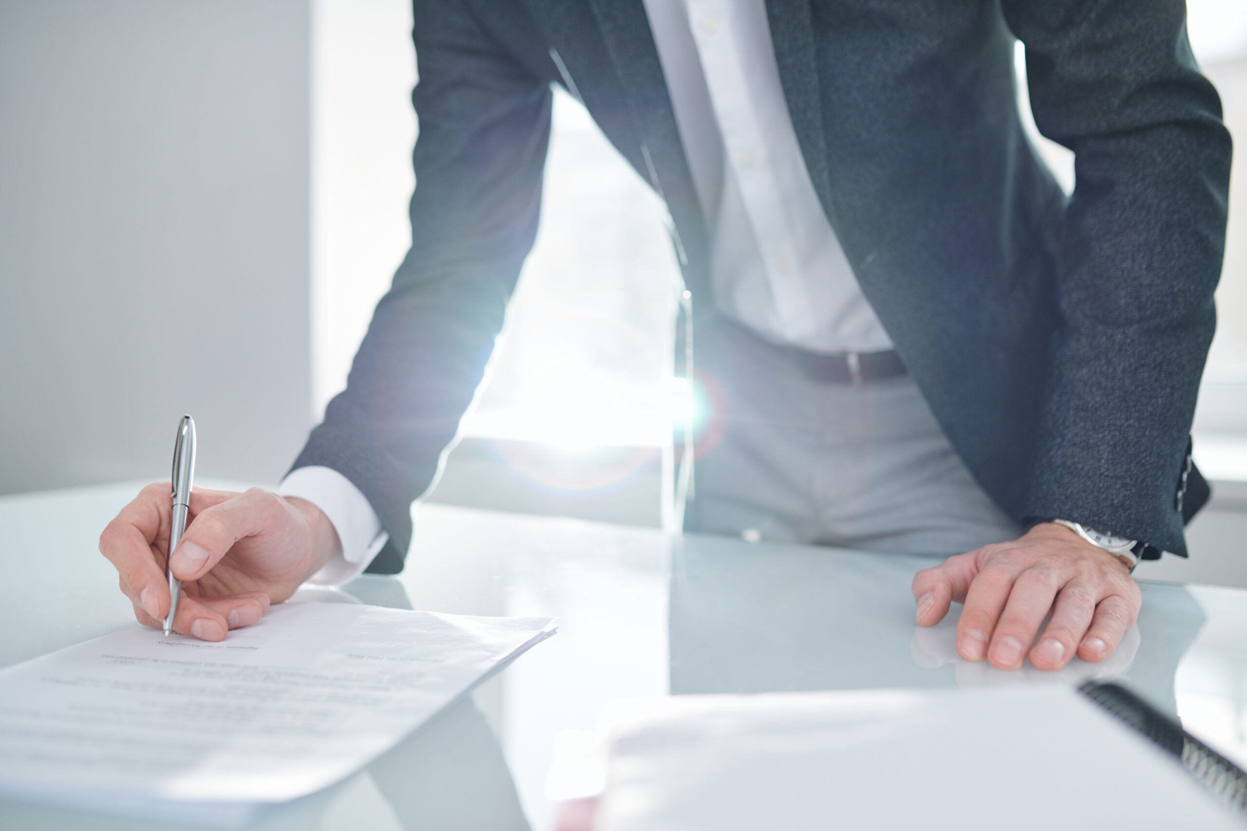 A businessman in a suit leaning over a desk | Jacko Law Group, PC