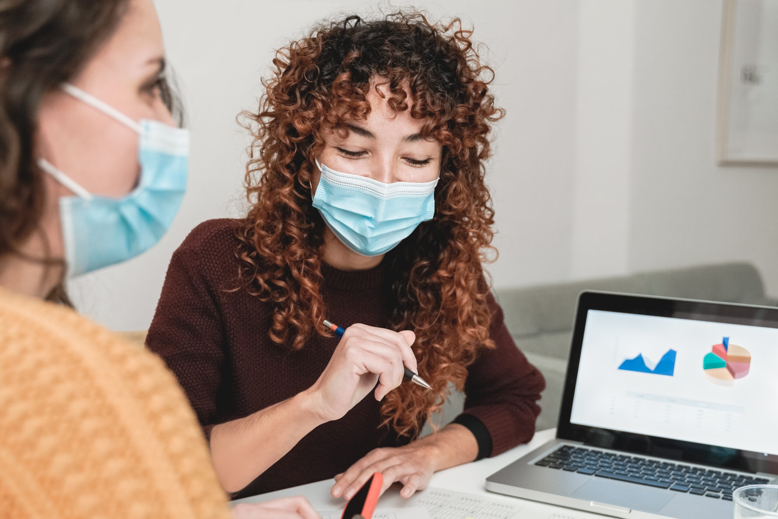 Two individuals engaged in a discussion around a laptop | Jacko Law Group, PC