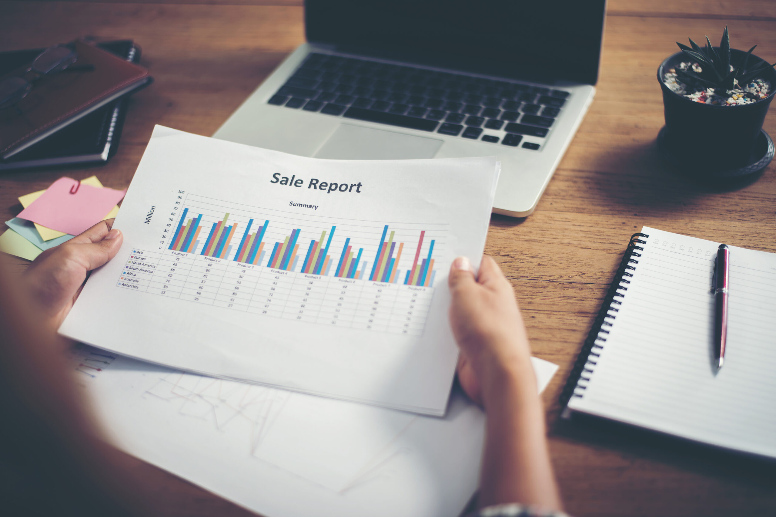 A detailed sales report laid out on a table | Jacko Law Group, PC